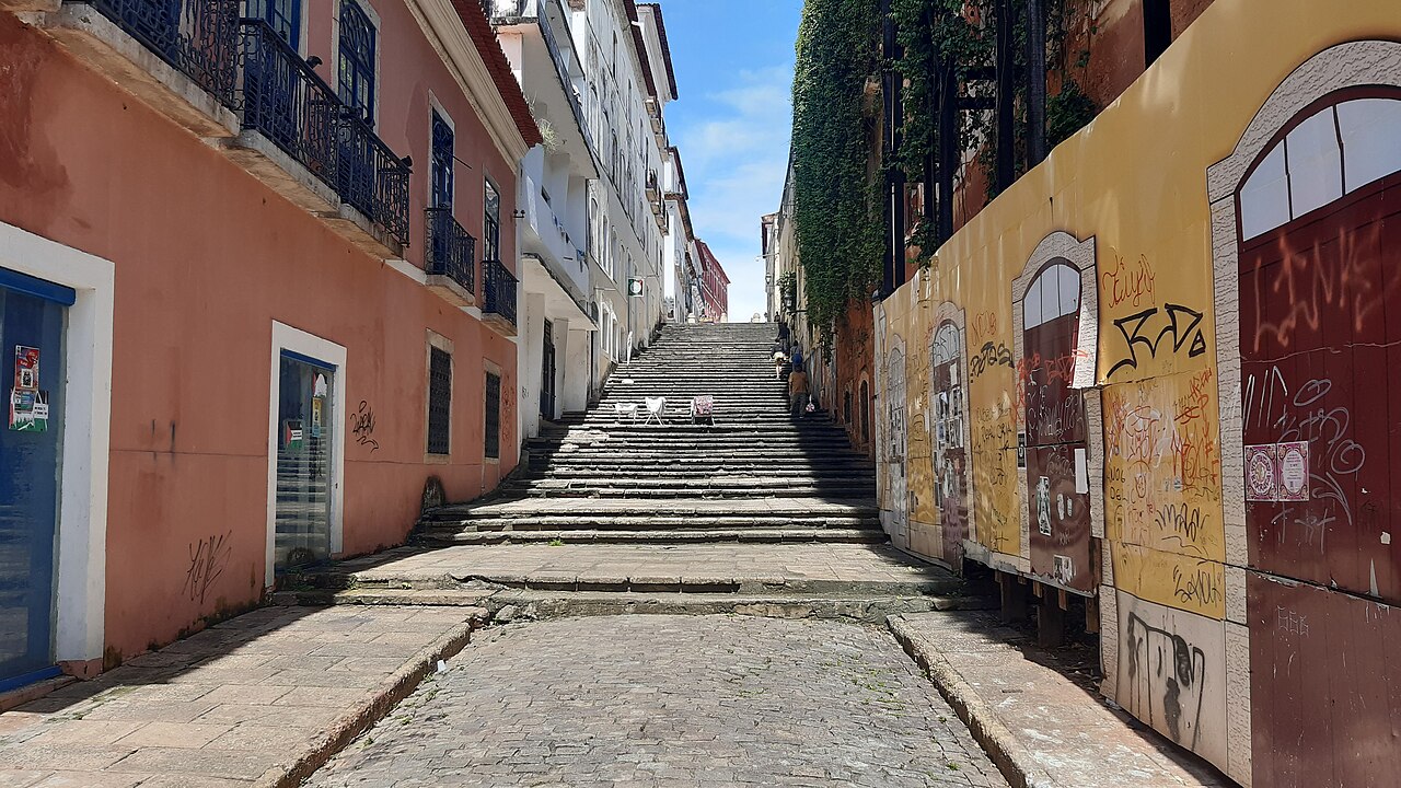 Rua de pedra e escadaria entre casarões coloniais do Centro Histórico de São Luís, Maranhão, sob céu azul